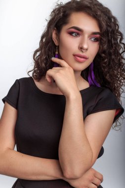 Romantik kız nazikçe yüzüne elinin tersiyle dokunuyor. Genç kadın yan bakıyor.