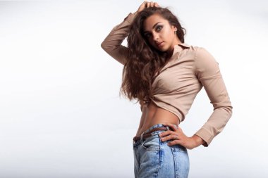 Karnı düz ve karnı şekilli çekici bir kadın. Stüdyoda kameraya poz veren sportif kız. Atletik vücudu ve güzel yüzü olan seksi bir model.. 