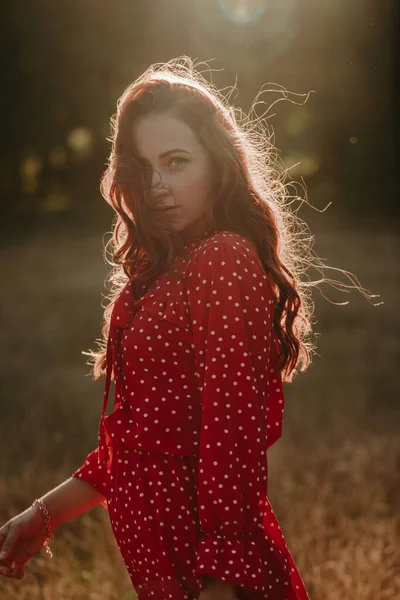 红头发的年轻女子 身穿红色衣服 背光背景为白点的中景肖像画 镜头前的女模特 — 图库照片
