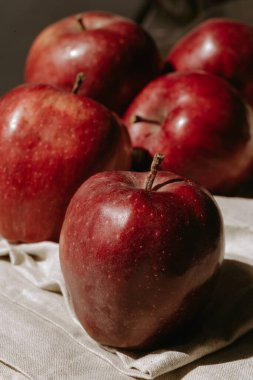 Kumaşın üzerinde birkaç kırmızı elma var. Tatlı ve sulu meyveler. Taze elma. Doğal yiyecek.
