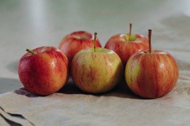 Olgun elmalar bir demet halinde masanın üzerinde yatıyor. Tatlı ve sulu meyveler. Taze elma. Doğal yiyecek.