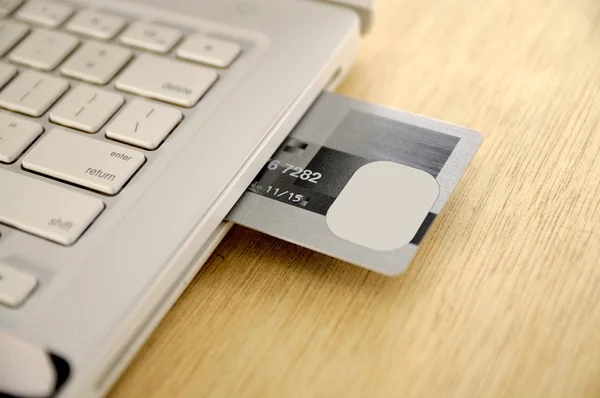 Inserção do cartão de crédito dentro do portátil — Fotografia de Stock