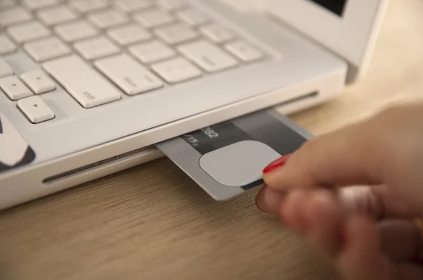 Inserção do cartão de crédito dentro do portátil — Fotografia de Stock