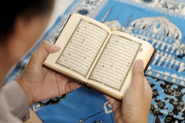 Молодой человек, читающий Священный Коран — стоковое фото
