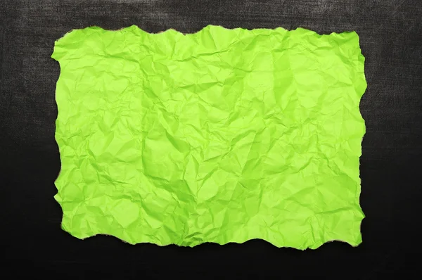 Papel queimado verde sobre chalkboard — Fotografia de Stock