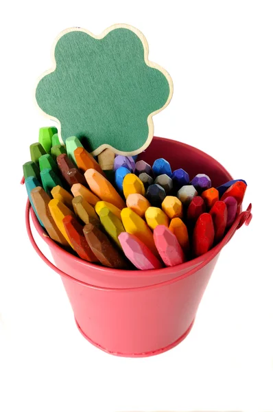 Green sign on metal bucket full of crayon — Stock Photo, Image