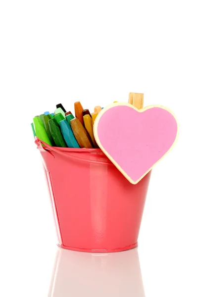 Heart shape sign on metal bucket full of crayon — Stock Photo, Image