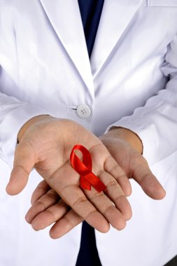 Doktor elini tutarak kırmızı kurdele