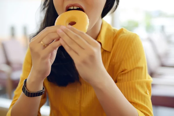 Женщина ест пончики — стоковое фото