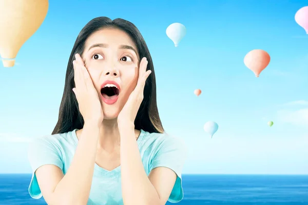 Mavi Arka Planda Uçan Renkli Hava Balonlu Asyalı Kadın — Stok fotoğraf