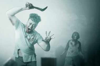 Vücudunda kan ve yara olan korkunç bir zombi. Mezarlıkta orak tutuyor.