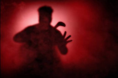 Dramatik bir geçmişi olan orak tutan korkunç bir zombinin silueti.