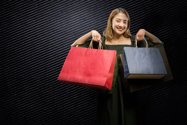 Siyah Arka Planı Olan Bir Alışveriş Çantası Taşıyan Asyalı Kadın — Stok fotoğraf