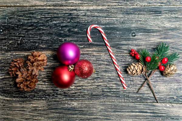 Çubuklu Çam Kozalağı Ahşap Arka Planda Renkli Bir Noel Topu — Stok fotoğraf