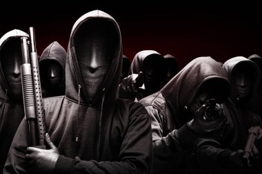 Siyah arka planda bir av tüfeği olan maskeli bir grup suçlu.