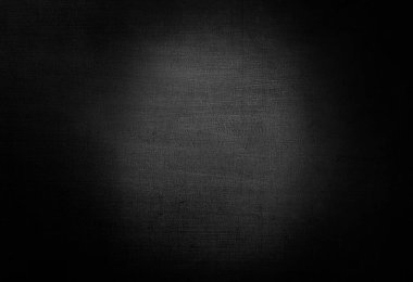 Karanlık odada ışığı olan beton bir duvar.