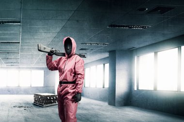 Soygundan sonra elinde tüfekle dolaşan pembe üniformalı ve maskeli bir suçlu.