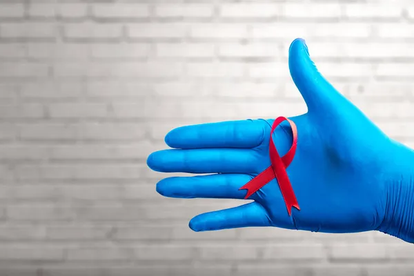 Fita Vermelha Luva Médica Com Fundo Parede Tijolo Hiv Aids — Fotografia de Stock