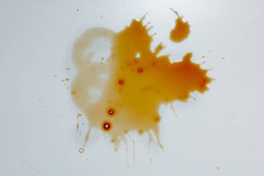 Beyaz arka planda kahve damlaları ve lekeler var.