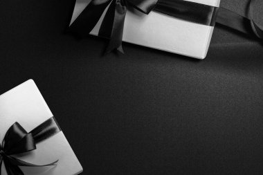 Siyah arka planda siyah kurdeleli beyaz hediye kutusu. Kara Cuma konsepti