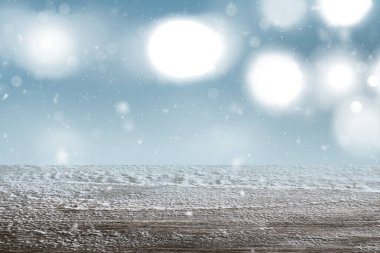 Bulanık ışık arkaplanı olan karlı ahşap masanın yakın görüntüsü