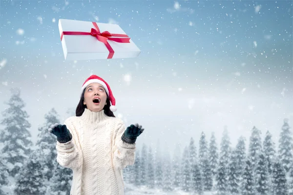 Asiatin Mit Winterhandschuhen Und Weihnachtsmütze Blickt Auf Weiße Geschenkbox Mütze — Stockfoto