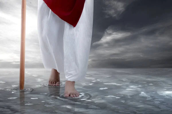 イエス キリストは劇的な背景を持つ水に棒で歩く — ストック写真