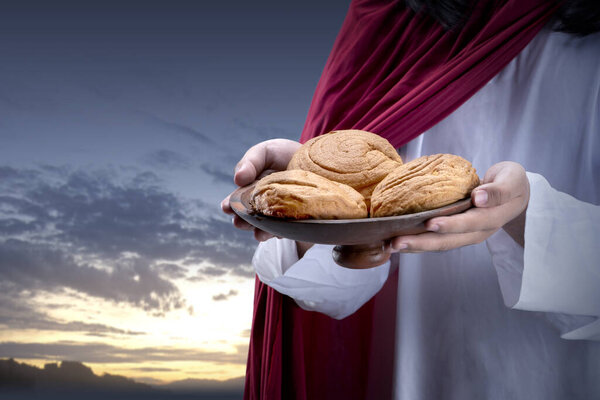 Jesus Christ holding food with dramatic sky background