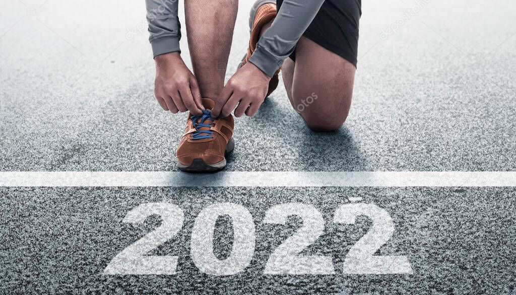 Runner man preparing to run on the 2022 line. Happy New Year 2022