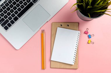 Laptop and note book with pencil with colored background