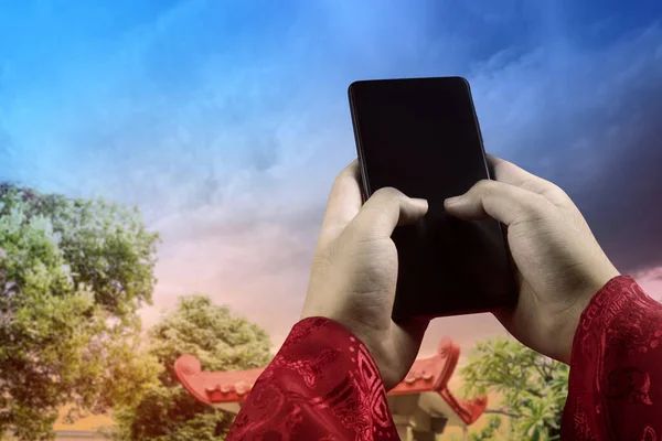 Ręczne Trzymanie Telefonu Komórkowego Dramatycznym Tle Nieba Szczęśliwego Chińskiego Nowego — Zdjęcie stockowe