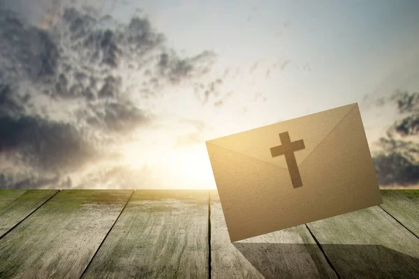 Envelope Com Cruz Cristã Mesa Madeira Com Fundo Céu Dramático — Fotografia de Stock