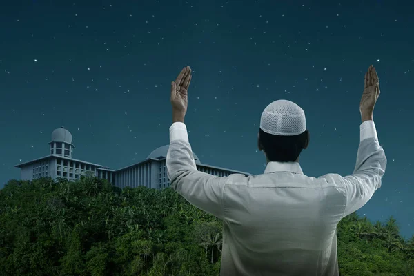 亚洲穆斯林男子高举着双手在夜晚祈祷时站立的背影 — 图库照片