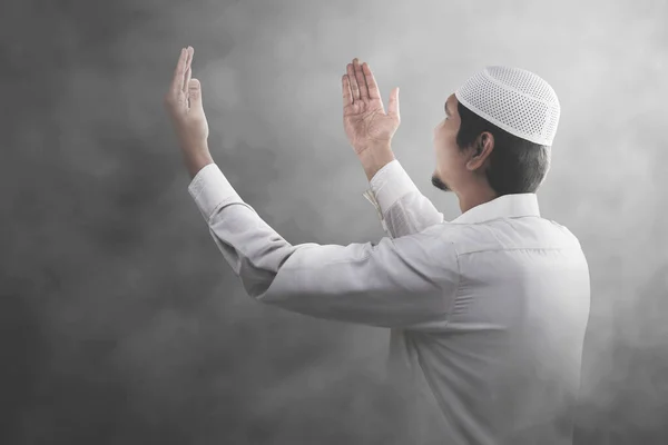 アジア系イスラム教徒の男性が立ち上がりながら手を挙げ 明るい背景で祈る — ストック写真