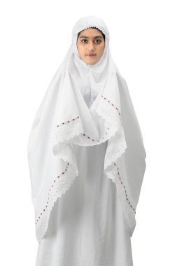 Asyalı Müslüman bir kadın duvak takmış elini kaldırmış ve beyaz arka planda tek başına dua ediyor.