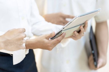 Tabletli bir iş adamı iş yerinde iş hakkında konuşuyor.