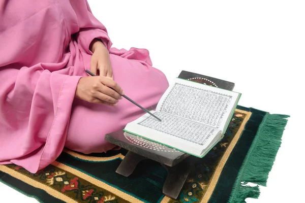 礼拝用の敷物の上に座っているベールにイスラム教徒の女性と白の背景に隔離されたクルアーンを読んで — ストック写真