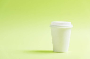 Renkli arka planı olan beyaz plastik bardak.