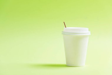 Renkli arka planı olan beyaz plastik bardak.