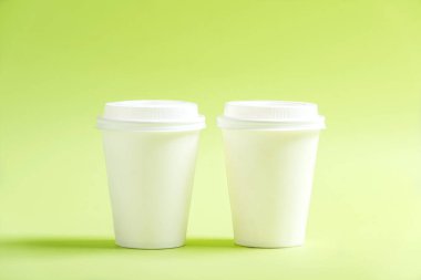 Renkli arka planı olan beyaz plastik bardak.