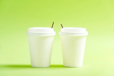 Renkli arka planı olan beyaz plastik bardak.