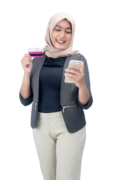 白い背景に隔離された携帯電話とクレジットカードを保持しているスカーフでアジアのイスラム教徒の女性 — ストック写真