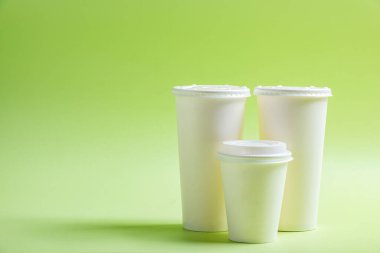 Renkli arka planı olan beyaz plastik bardak.