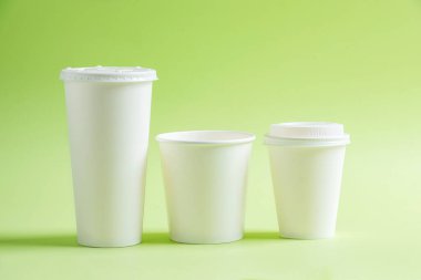 Renkli arka planı olan beyaz plastik bardak.