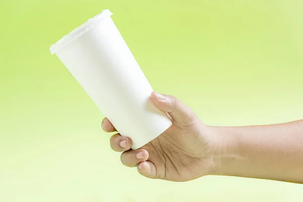 Menschliche Hand Hält Einen Weißen Plastikbecher Mit Farbigem Hintergrund — Stockfoto