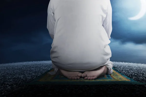 在有夜景背景的祈祷地毯上 近距离观察一名站在祈祷位置 的穆斯林男子 — 图库照片