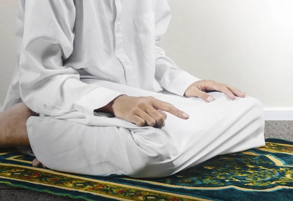 在白墙背景的祈祷地毯上 近距离观察一名站在祈祷位置 的穆斯林男子 — 图库照片