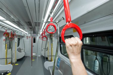 Güvenlik için trende el ele tutuşan yolcu.