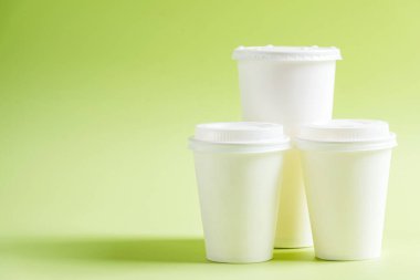 Renkli arka planı olan beyaz plastik bardak.