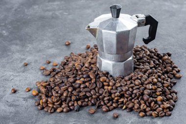 Kahve çekirdekleri ve kahve makinesi dokulu arka planda.